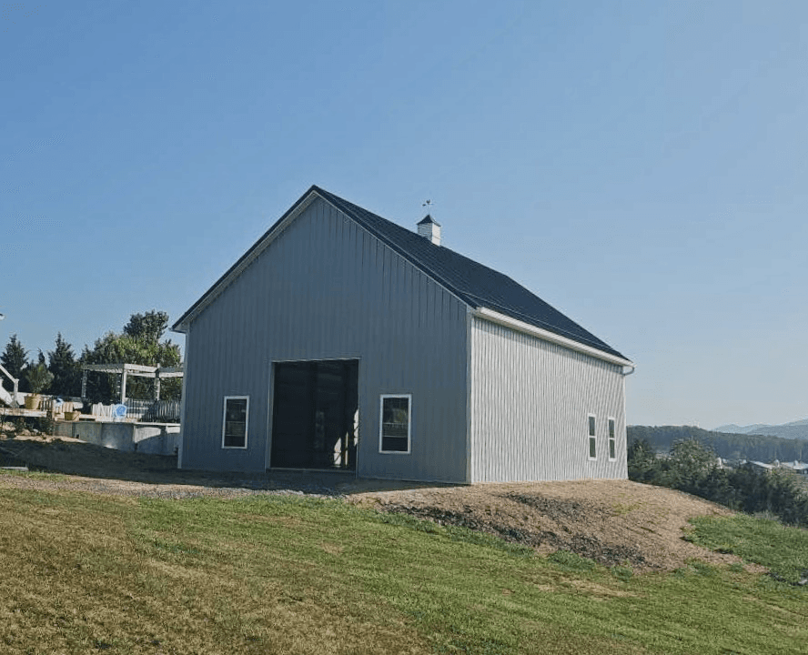 Completed Strongbuilds LLC post-frame building with dark metal roof in Shanks, WV